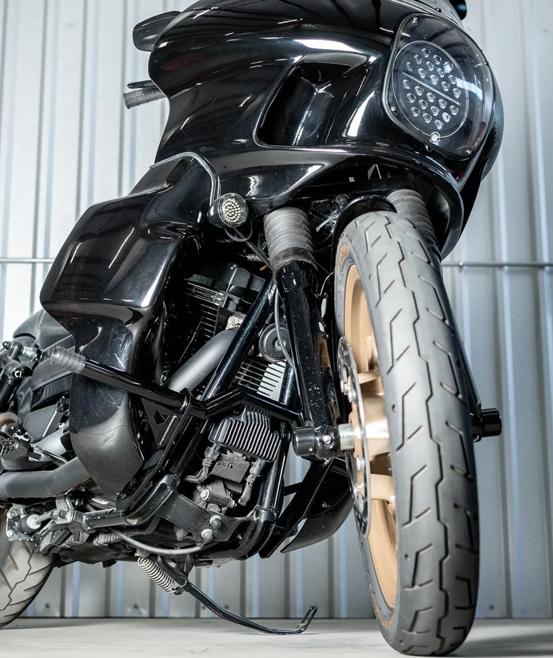 A black motorcycle crash bar installed on a motorcycle, designed to protect the paint job during falls or tipovers., photo 6 of 6
